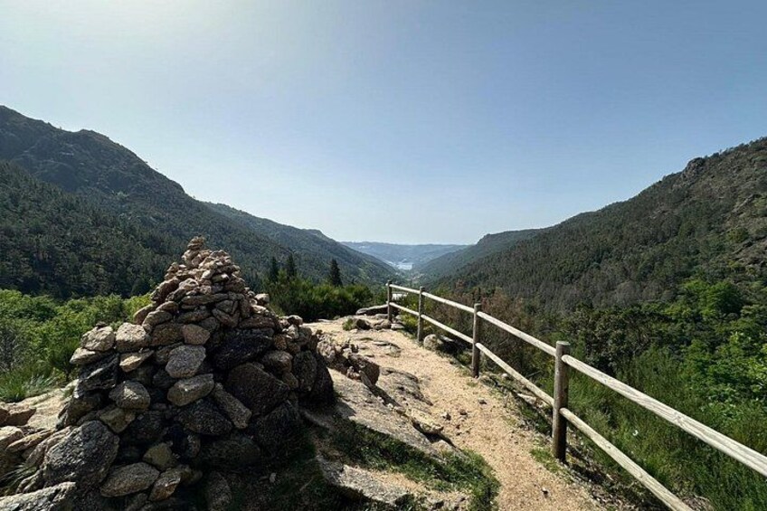 A stone structure, a wooden fence, and a mountainous landscape. 4