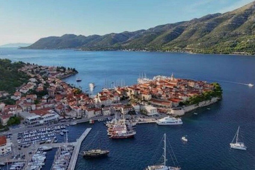 A coastal town with a harbor, boats, and a mountainous backdrop. 4