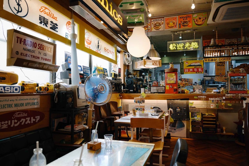 A restaurant interior with various signs, including Toshiba and Sony, and a TV service advertisement. 1