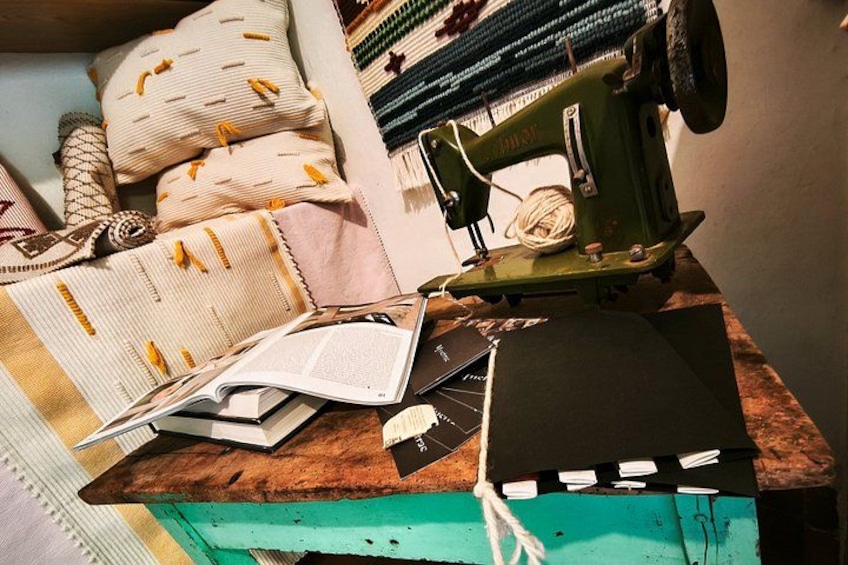 A sewing machine, a book, and various fabrics on a wooden table. 4