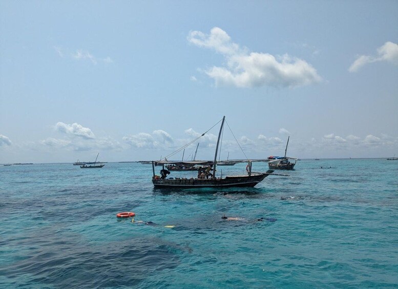 A calm sea with several boats anchored. 4