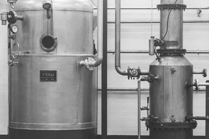 Industrial equipment, including a large cylindrical tank and a smaller vertical structure with pipes and valves. 1