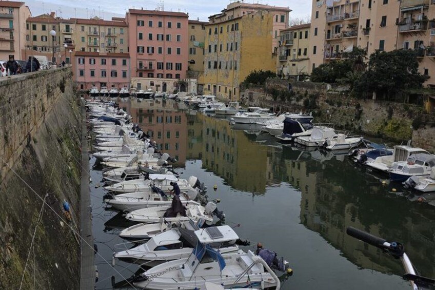 A canal lined with boats and buildings. 4