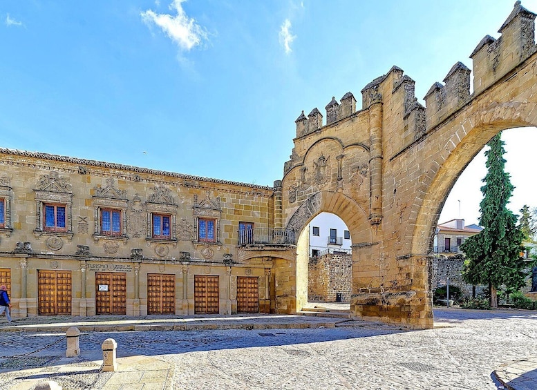 A historic stone building with arched windows and a large stone archway. 4