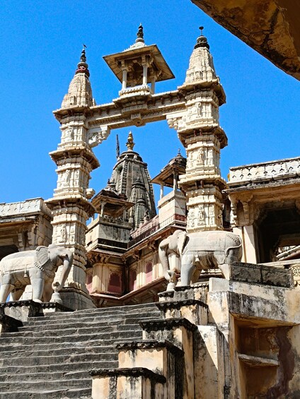 A temple with intricate carvings, a central spire, and elephant statues. 5