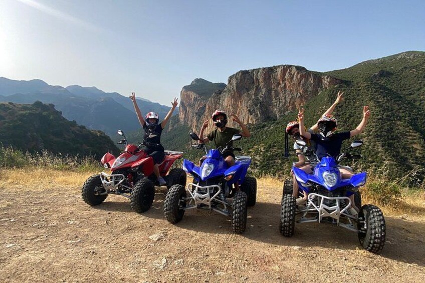 Three off-road vehicles on a dirt path with a mountainous landscape in the background. 4