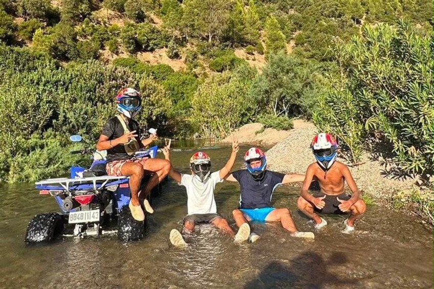 A group of people on a riverbank, some on a vehicle and others in the water. 4