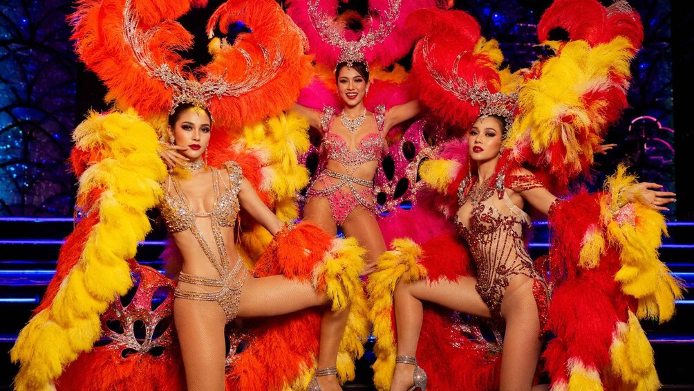 Performers in elaborate costumes with feathered headdresses and sparkling jewelry. 3