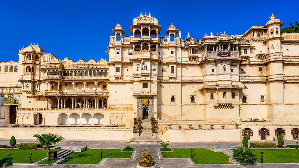 A grand palace with intricate architecture, a central entrance, and a well-maintained garden. 1