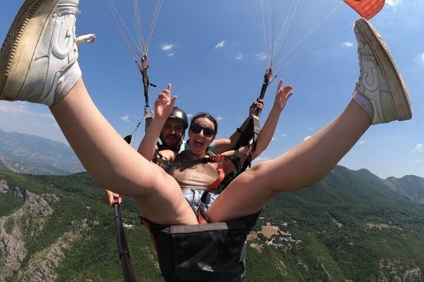 A person paragliding with a mountainous landscape in the background. 5