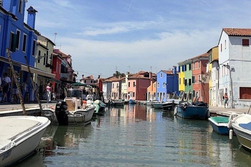 A canal with boats, colorful buildings, and people. 2