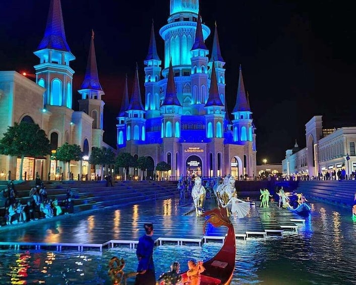 A castle-like building with multiple spires, illuminated by blue lights, and a water fountain with figures in boats. 2