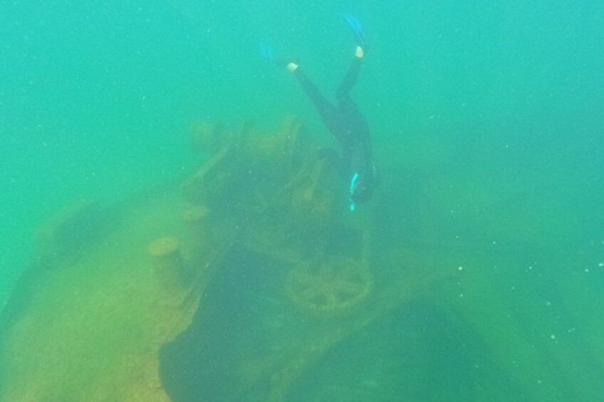 A diver underwater near a shipwreck. 4
