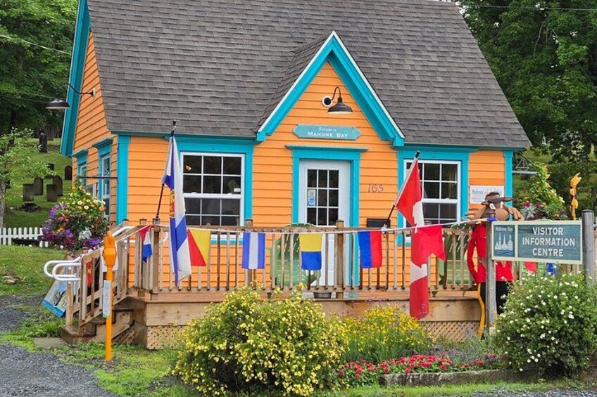 A colorful building with a sign reading 'Visitor Information Centre' and flags on the porch. 3