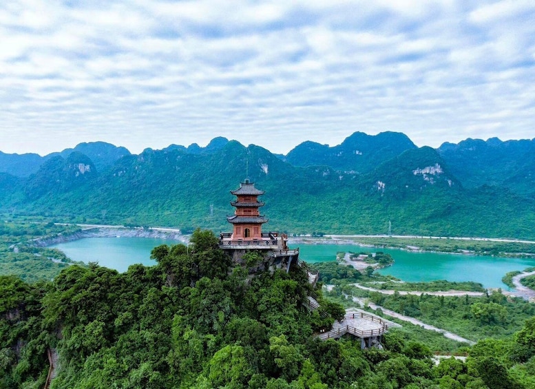 A pagoda on a cliff overlooking a river and mountains. 1