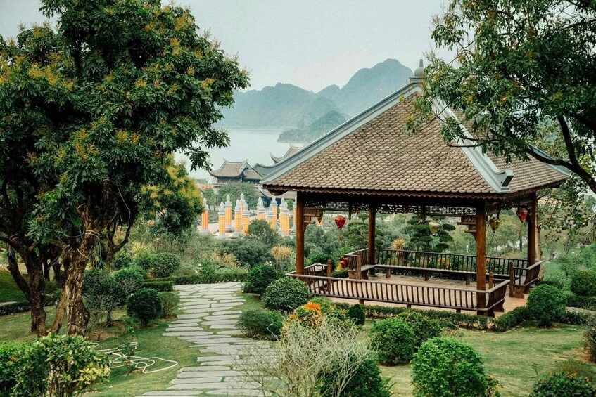 A traditional pavilion in a lush garden with a stone pathway leading to a distant pagoda. 2
