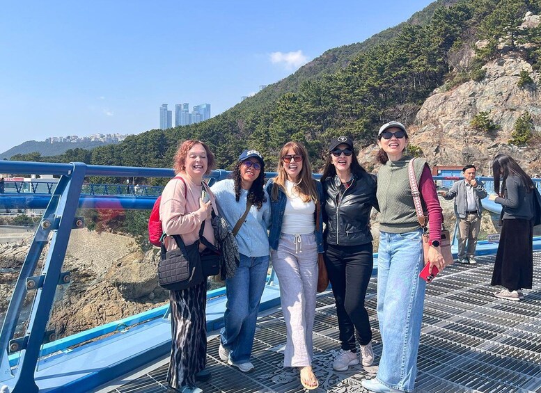 A group of people standing on a bridge with a mountainous landscape in the background. 2