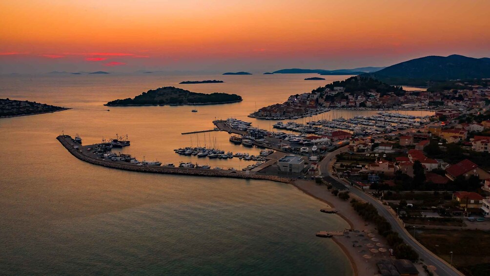 A coastal town at sunset with a marina and boats. 4