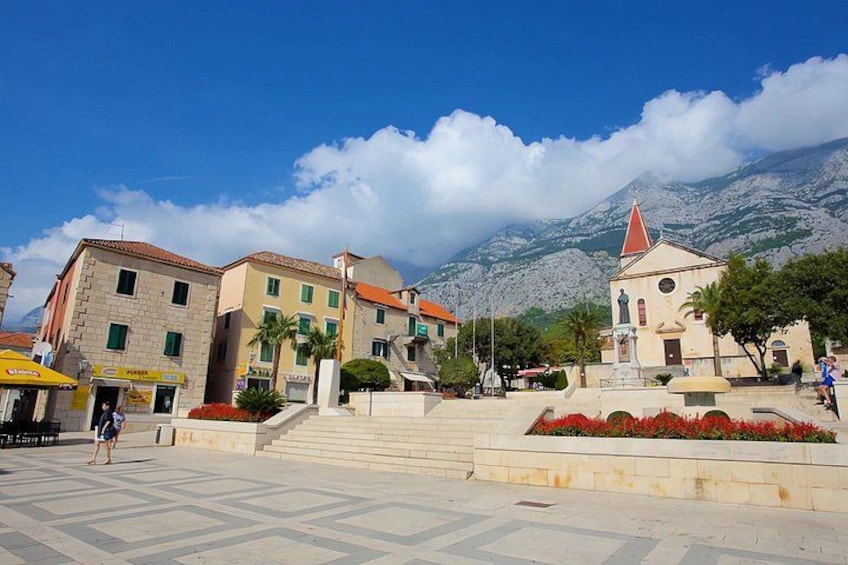 A town square with buildings, a church, and a mountain in the background. 3