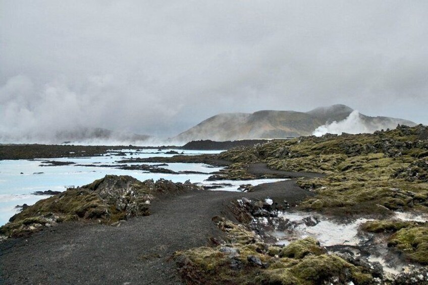 A volcanic landscape with a lava field, rocky terrain, and a distant mountain. 3