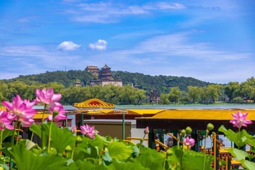 A traditional Chinese pagoda by a lake with lotus flowers in the foreground. 2