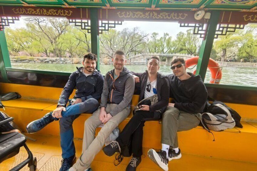 Four people sitting on a yellow bench inside a boat with a waterway and trees in the background. 3