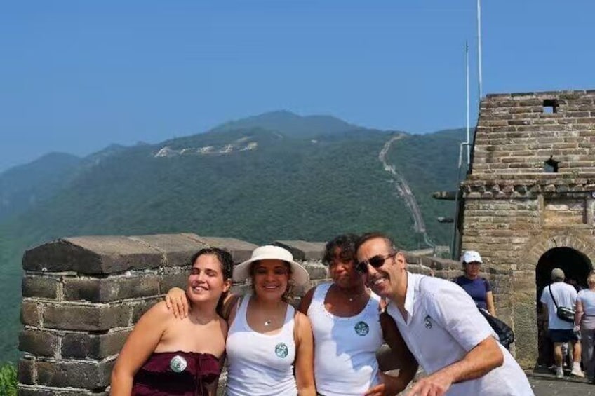 A group of people at the Great Wall of China with a mountainous backdrop. 5