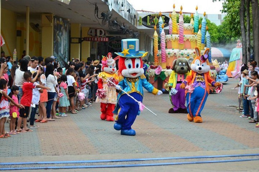 A parade with large mascot characters and a crowd of spectators. 4