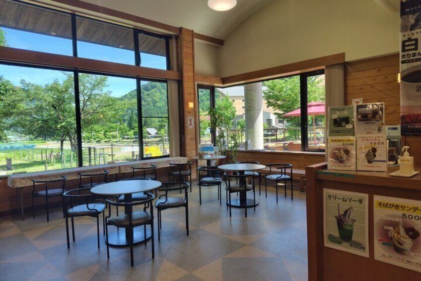 An indoor dining area with large windows, tables, and chairs. 4