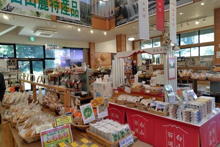 A store with various packaged goods, including snacks and possibly pet food, displayed on shelves and tables. 3