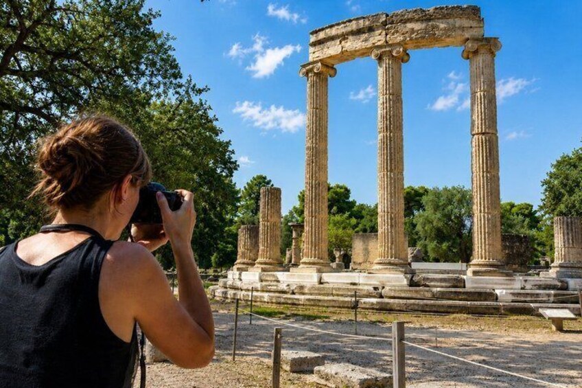 A person taking a photo of ancient columns. 5