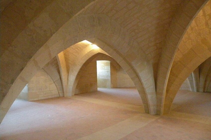 An interior with arched ceilings and a central light source. 2