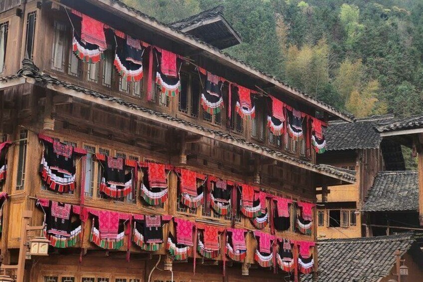 A traditional wooden building with multiple balconies adorned with colorful fabric decorations. 5