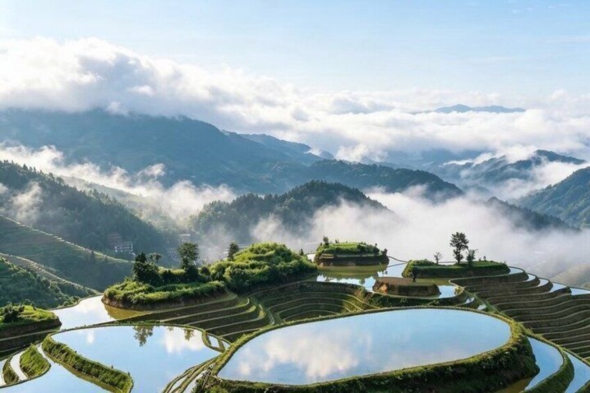 Terraced rice fields, a mountain range, and a misty atmosphere. 3