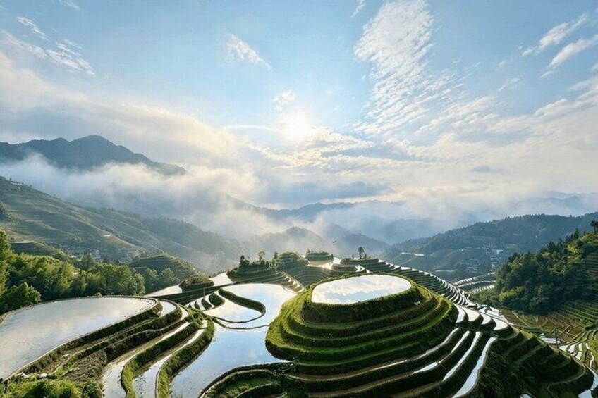 Terraced rice fields, a mountain range, and a misty atmosphere. 4