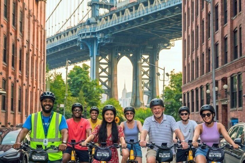 A group of people on bicycles with a bridge in the background. 1