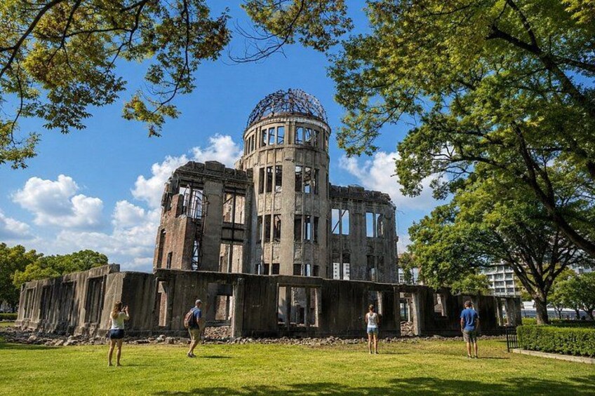 A historical building with a dome and columns, surrounded by a grassy area and trees. 2