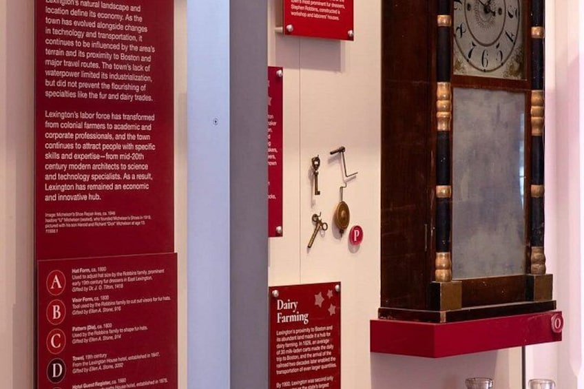 A historical exhibit with a large clock, keys, and informational plaques. 3