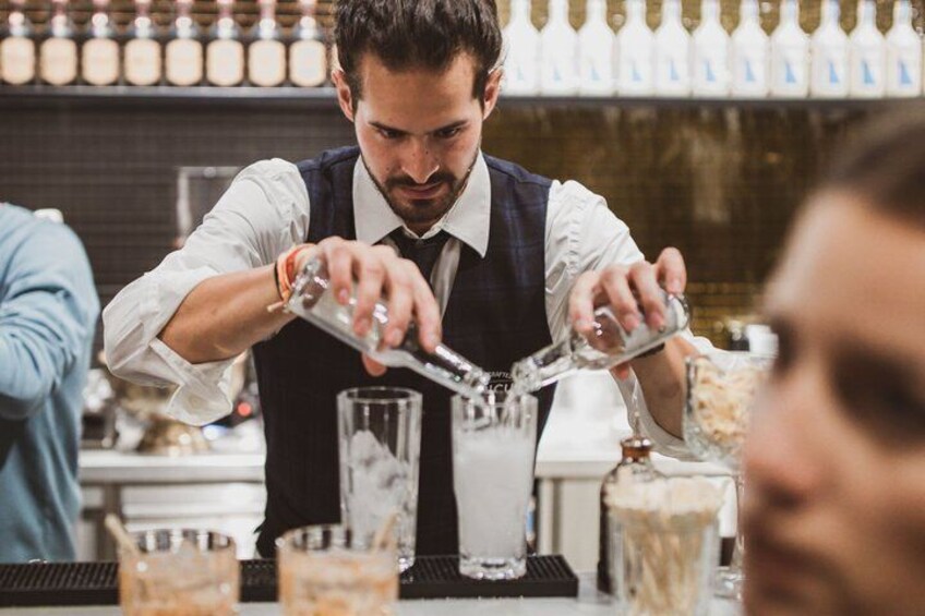 A bartender pouring a drink into a glass. 2