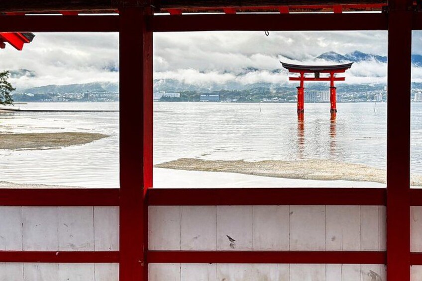 A red torii gate in water, a wooden structure, and a mountainous landscape in the background. 4
