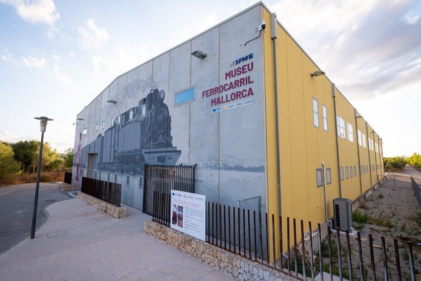 A building with a mural of a train and the text 'Museu Ferro Carril Mallorca'. 1