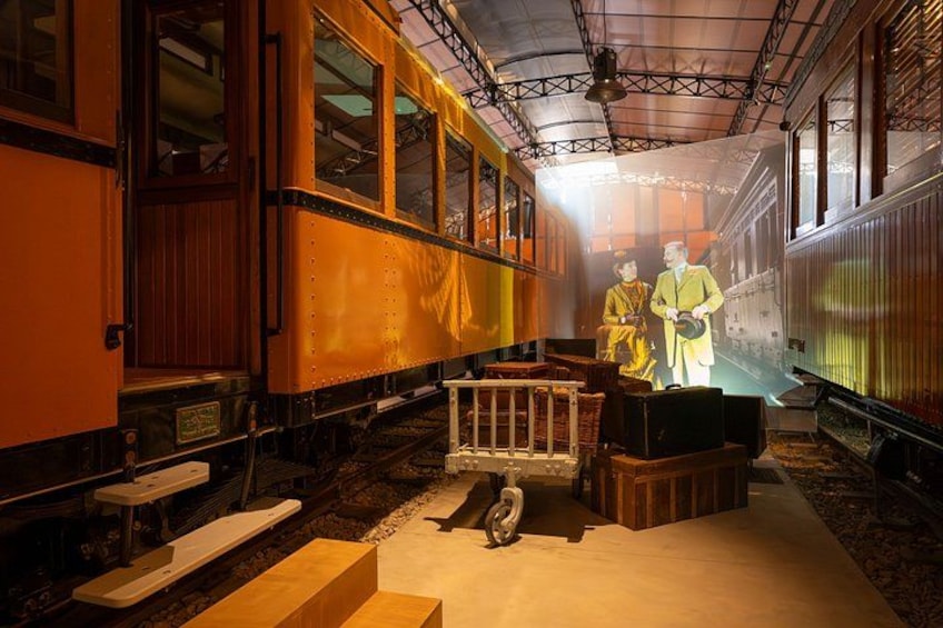 A vintage train carriage with wooden benches and a vintage suitcase. 2