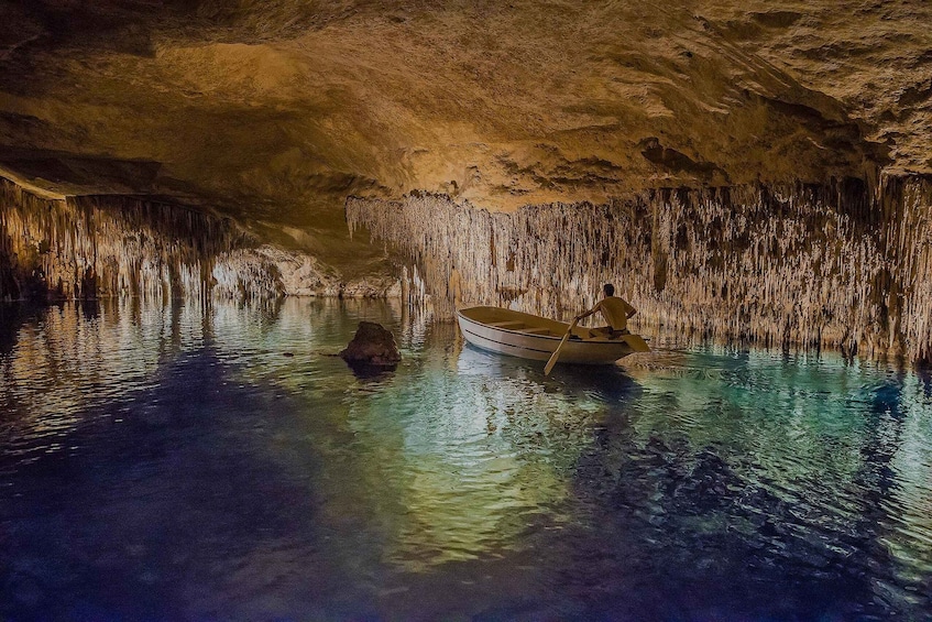 A cave with stalactites and a boat on the water. 4