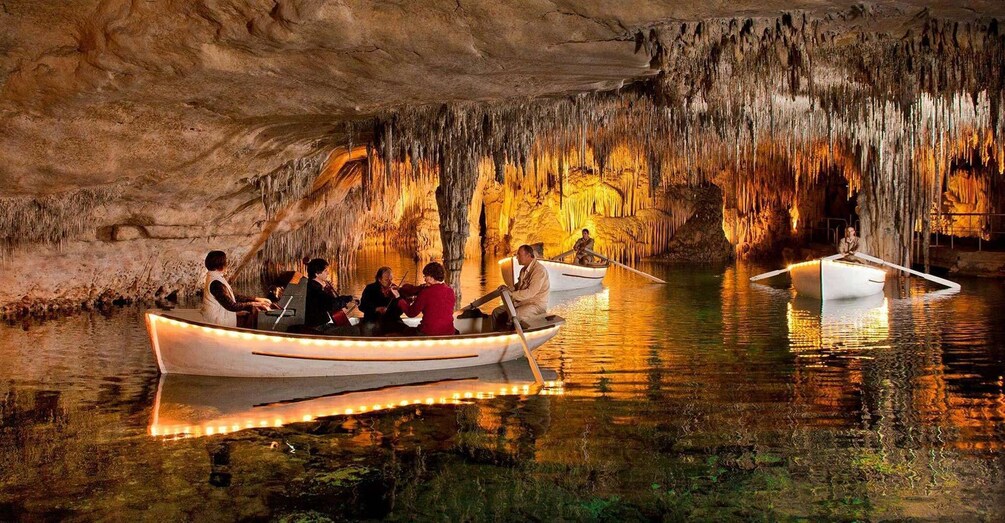 A group of people in a boat inside a cave with illuminated walls. 1