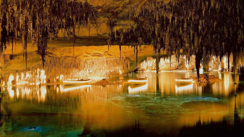 A cave with stalactites and stalagmites, a calm lake, and a boat. 3