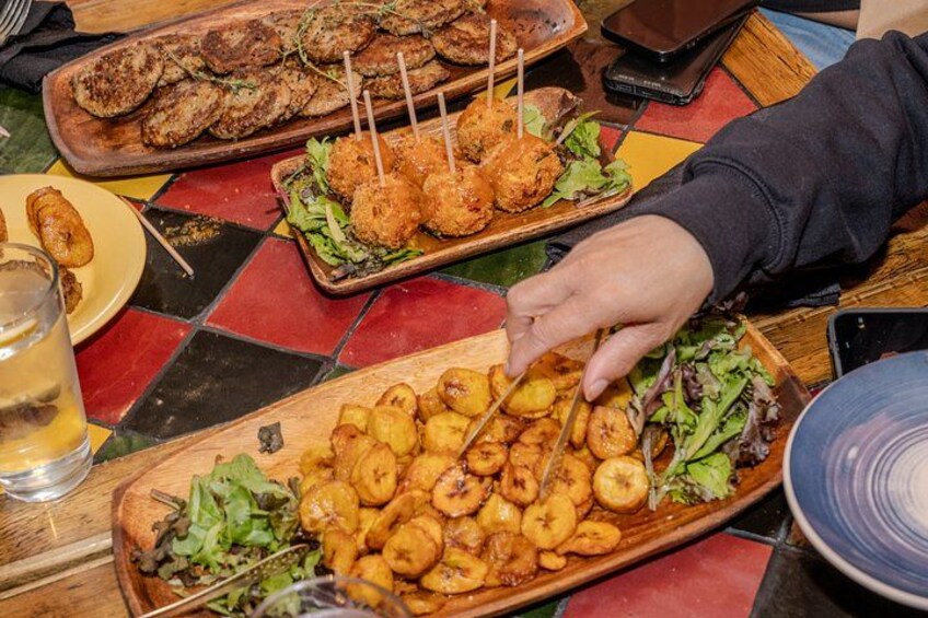 A person serving food from a wooden tray. 2