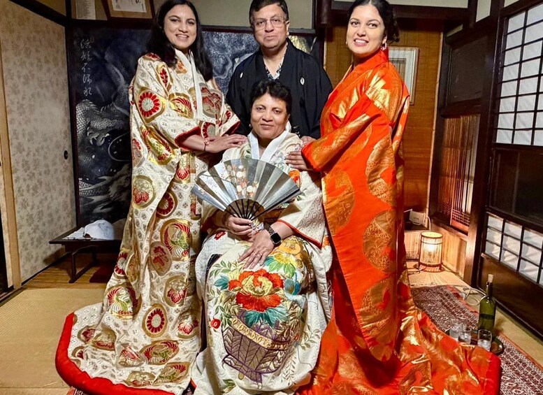 Un grupo de personas con vestimenta tradicional, un abanico, y una habitación con esteras de tatami y puertas correderas shoji. 1