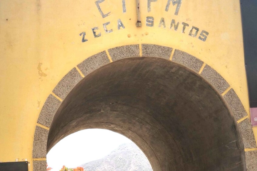 Holvikaarinen tunnelin sisäänkäynti, jonka seinässä on kaiverrettu teksti: ”CIMA ZEECA SANTOS”. 4