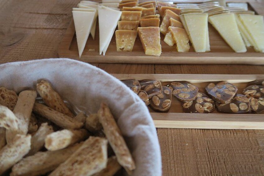 A wooden table with various cheeses and crackers. 5