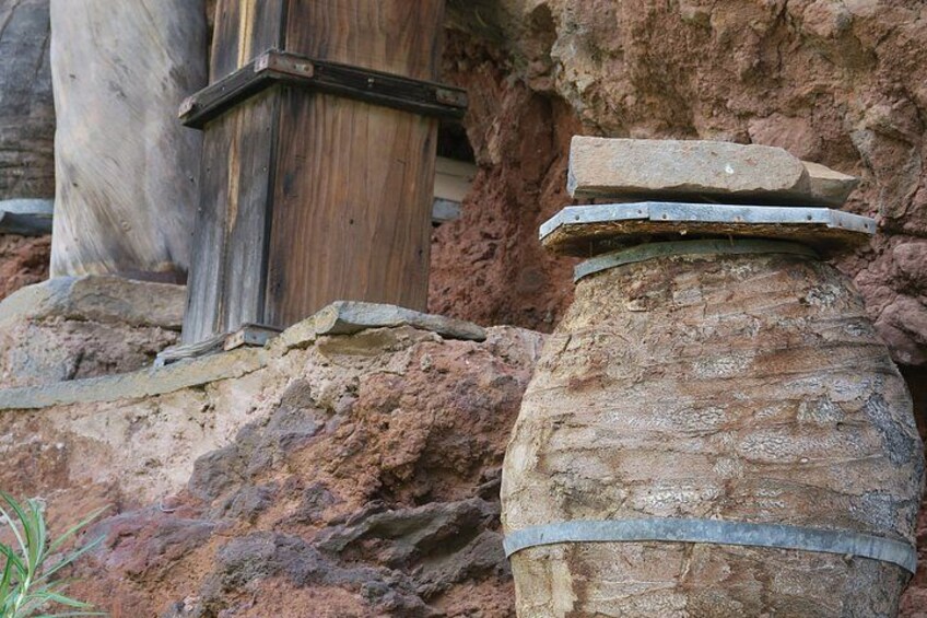 A rustic stone structure with a wooden beam and a metal band. 2
